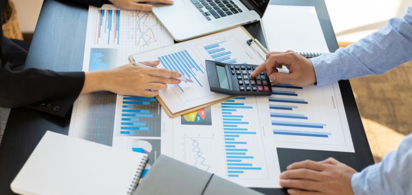 Business people calculations about charts and graphs showing the growth of investment results.