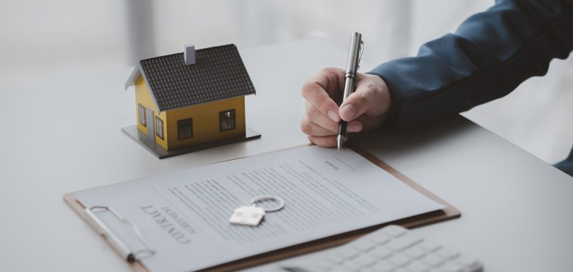 House and real estate agents, house salesmen with house models and house purchase contract documents