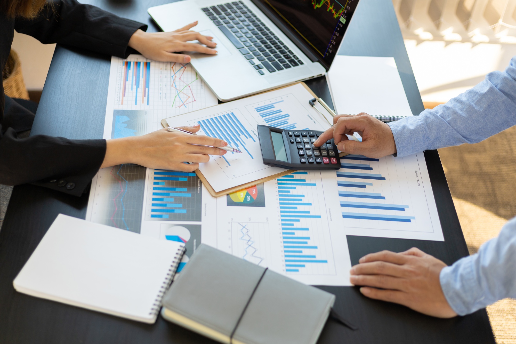 Business people calculations about charts and graphs showing the growth of investment results.