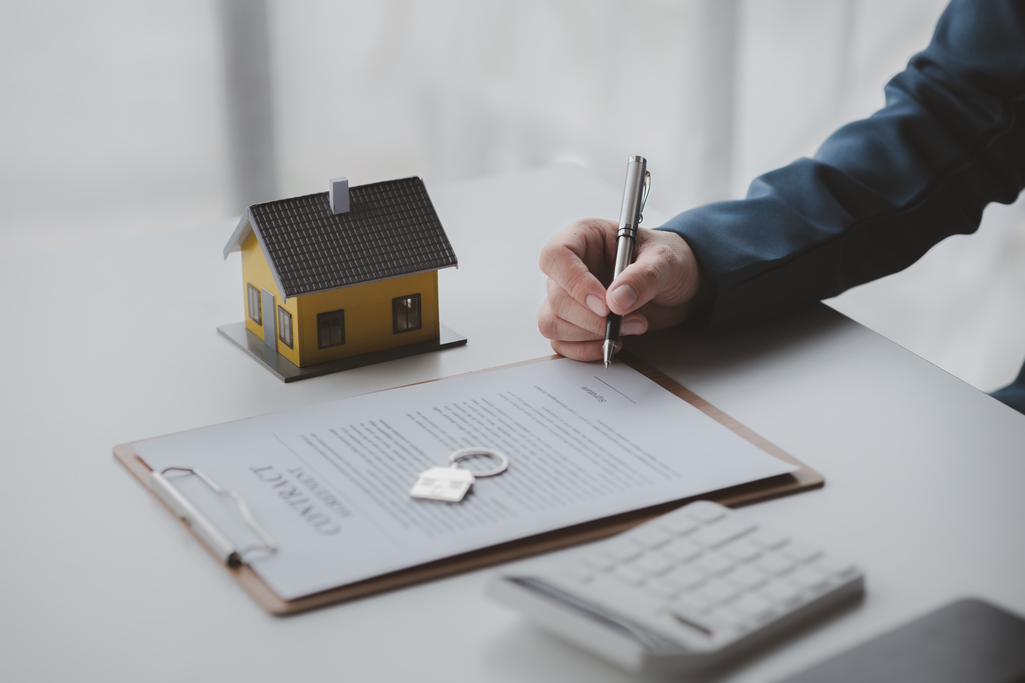 House and real estate agents, house salesmen with house models and house purchase contract documents